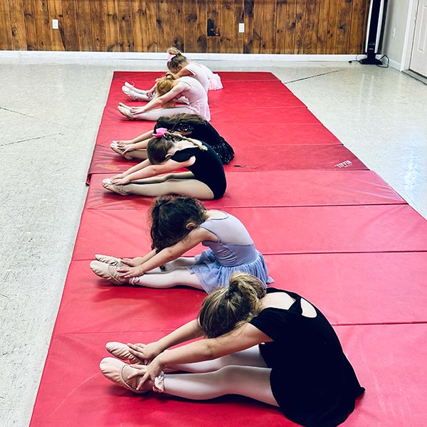 preschoolers working on their flexibility for tumbling class.