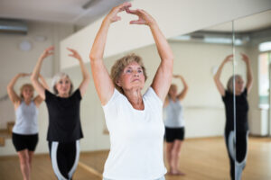 Portrait of a mature woman, standing at the 5th position of the ballet stand adults in ballet class working on balance and strength