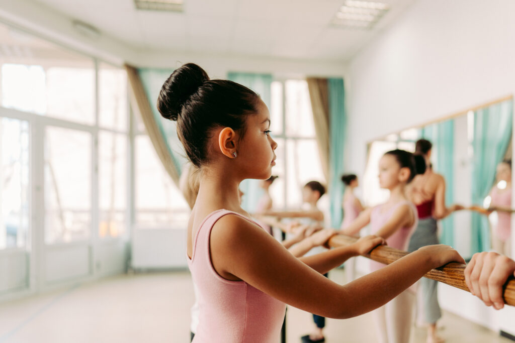 intermediate ballet student working on her posture at the ballet barre