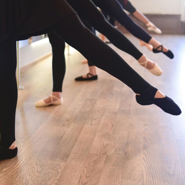 ballet dancers at the barre working on their dedege and turnout