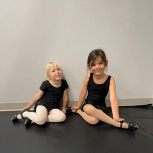 two young dancers smiling while taking a tap dance class