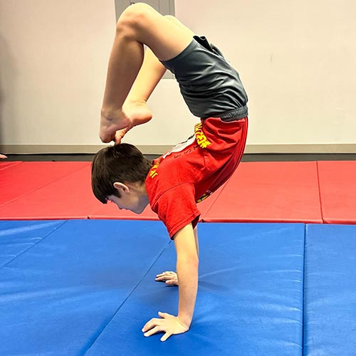 young boy in tumbling class at LA Dance Academy working on his handstands