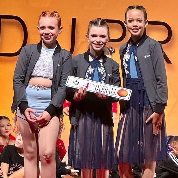 dancers getting their overall award on stage after working hard togehter