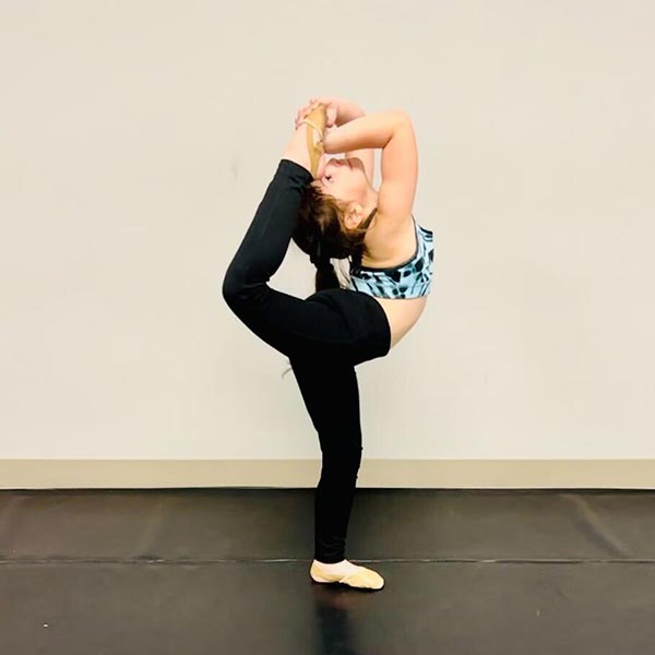 young girl working on her scorpion in class at LA Dance Academy