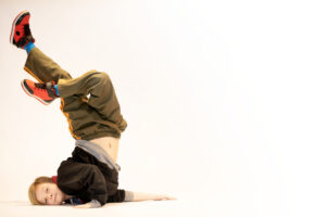 Young boy doing a break dance shoulder stand during his boys only hip hop class at LA Dance Academy