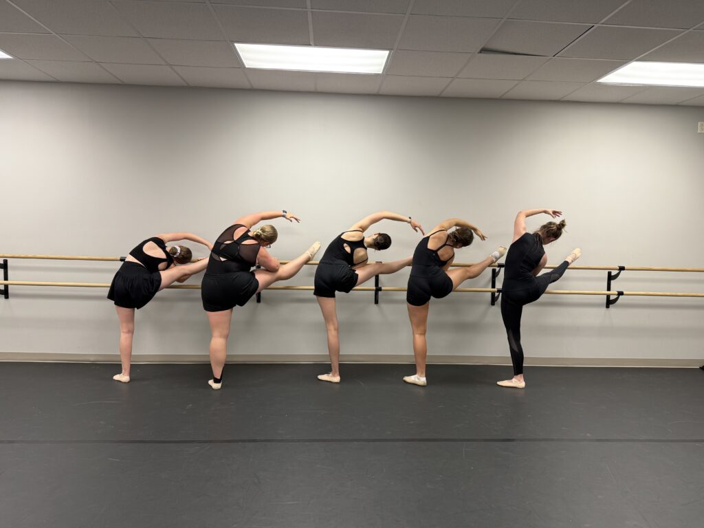 Ballet III - leg stretch Advanced ballerinas stretching at the barre