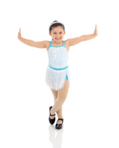 Preschool tap dancer has a huge smile on her face showing off her balance in her tap class at LA Dance Academy