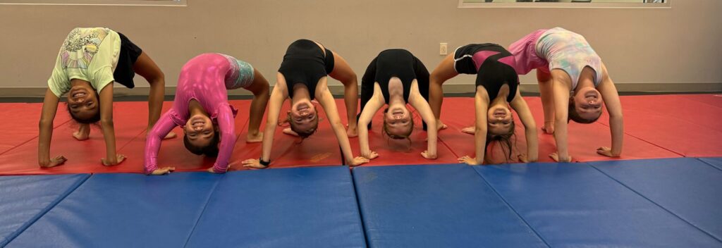 Tumbling class all in a backbend smiling for their teacher at LA Dance Academy.