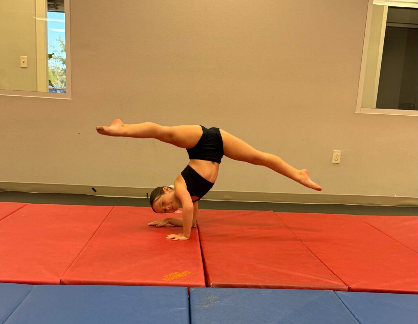 Tumbling intermediate student working on her elbow stand with perfect turnout.