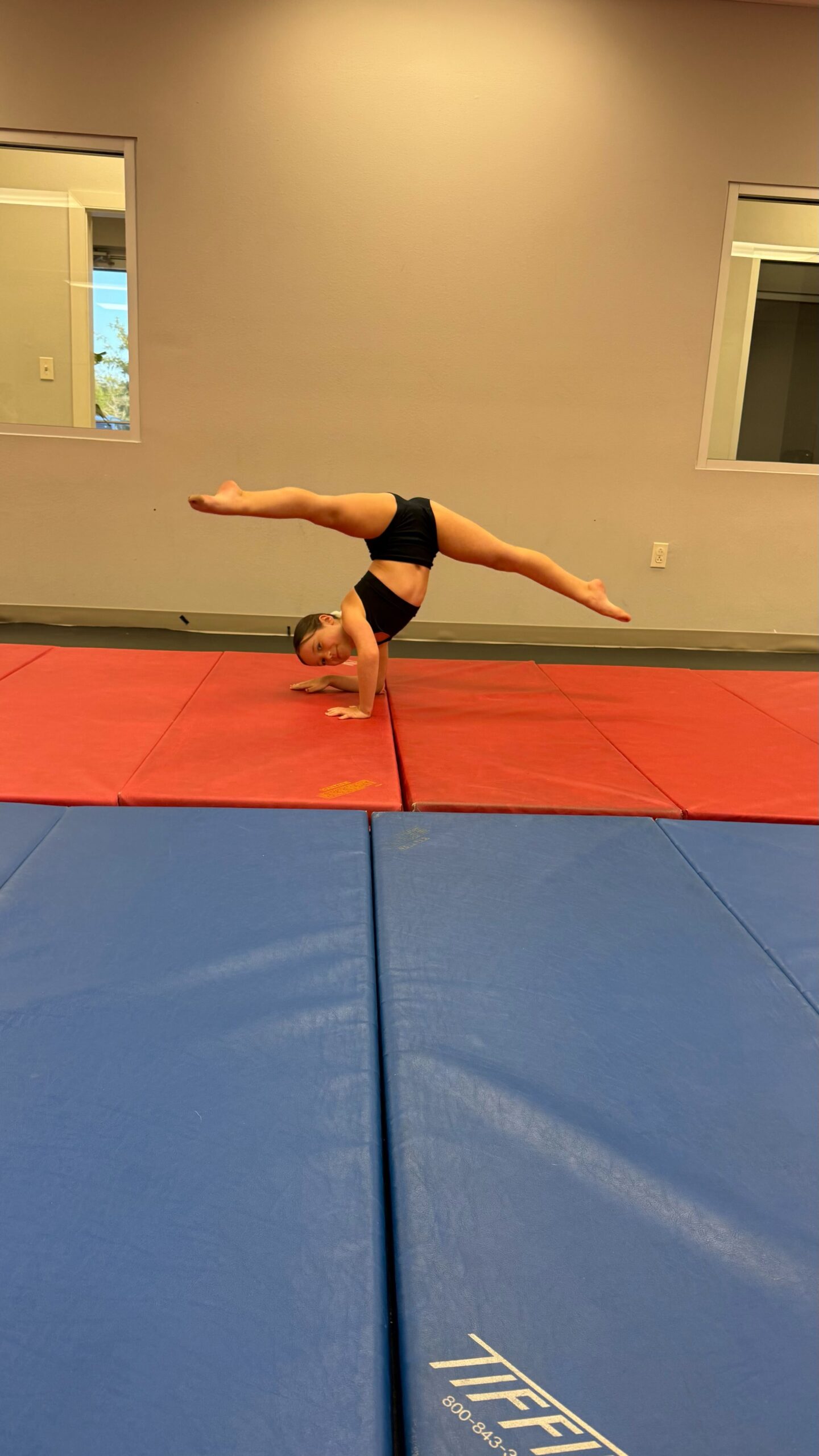 Tumbling intermediate student working on her elbow stand with perfect turnout.