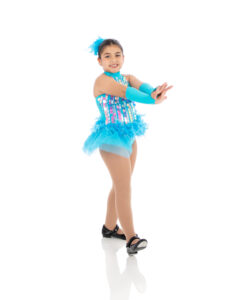 Tap Beginner Combo II Beginner level tap dancer doing an heel step with her arms strong and with a smile on her face.