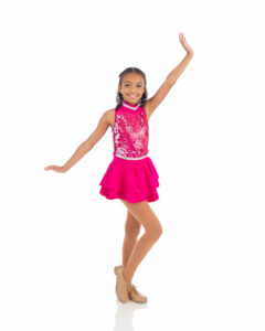 Tap II dig pose A beginner intermediate tap dancer showing off her tap technique in a bring pink costume for the annual recital at LA Dance Academy.