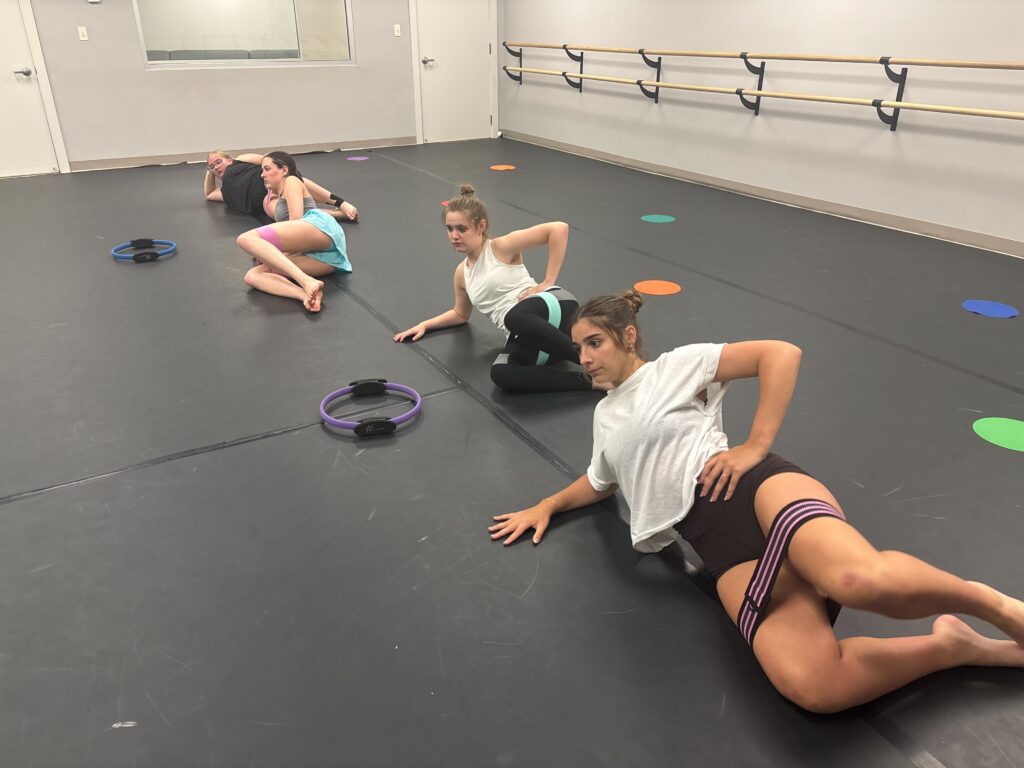 Dancers are using resistant bands for strength, alignment and core work during a conditioning class at LA Dance Academy.